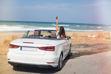 Couple in love traveling by white cabriolet car.