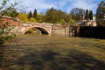 Old arched brick bridge across a pond in Sharovka Palace park in in Kharkov region, Ukraine