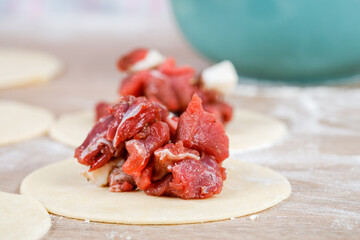 A man is holding a khinkali in close-up. Cook in the kitchen. The process of preparing a national dish.