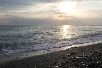 Sunset on the seashore. An empty beach. Calm sea at sunset. The concept of privacy and relaxation.