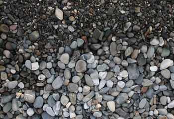 Sea coast, pebble beach background. The surf line. Raw and dry sanded pebbles. The concept of tranquility.