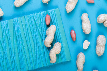 fresh peanuts in a shell on a bright blue slate, concrete or stone background. lots of nuts. the concept of proper nutrition. top view.