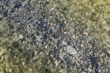 a blurry tilt-shift pattern of polished stones in a rocky beach
