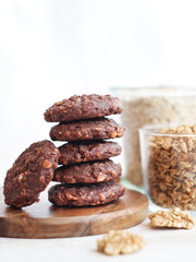 A healthy low-carb and high fiber oatmeal-walnuts with chocolate cookies with grains, cereals on a wooden plate 