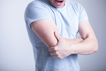 a man in a white shirt touches his hand
