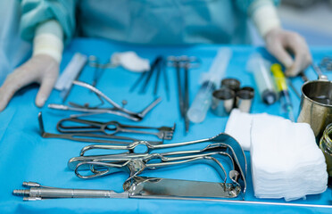Surgical instruments and tools in the operating room. Doctor at the background. Operating tools in medical table. Selective focus