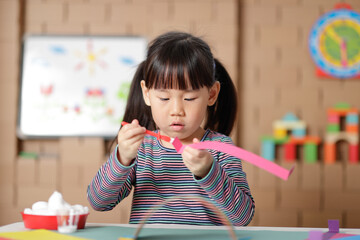 young girl making paper craft for homeschooling