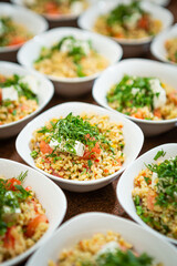 plates of vegetarian food are in a row on the table, spelled with tomatoes and herbs