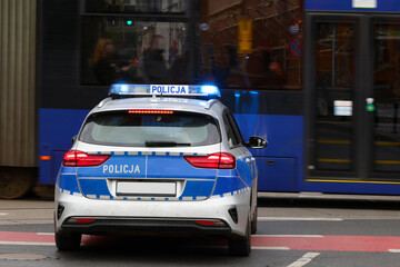 Samochód służbowy polskiej policji państwowej podczas akcji ratunkowej w mieście. 