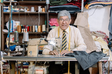 Portrait of an old Mexican tailor working with sewing machine
