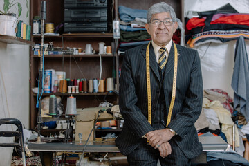 Portrait of an old Mexican tailor on his workshop, environmental portrait
