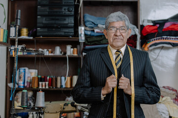 Fototapeta na wymiar Portrait of an old Mexican tailor on his workshop, environmental portrait