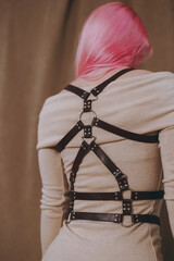 Fototapeta na wymiar Leather black harnesses on the girl over the clothes