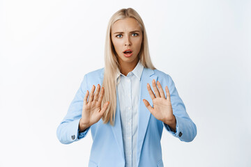 Stop it. Serious businesswoman stretching hands to show stay back gesture, prohibit or reject...
