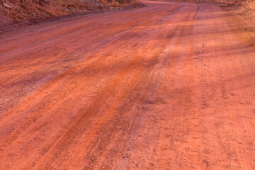 Red dirt road polluted with the iron ore. Environmental pollution