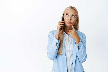 Thoughtful businesswoman having phone call, thinking or making decision during conversation, white background