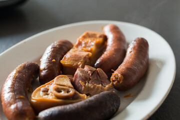 Close up of compango, side dish with meat, chorizo, jam and blood sausages to add the traditional...