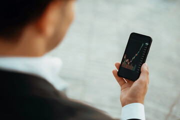 A trader trades on the stock exchange in his phone