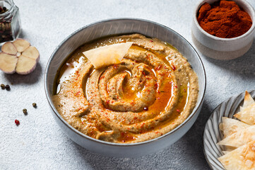 Traditional arabian eggplant dip baba ganoush with herbs and smoked paprika on light background. Eggplant hummus. Babaganush or eggplant caviar. Baked eggplant. Turkish eggplant dip