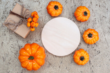 Wooden empty round sign template with copy space and fall decor from pumpkins and gift box on...