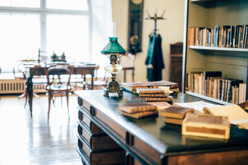 interior of an old house cabinet with books, wooden furniture and lamp