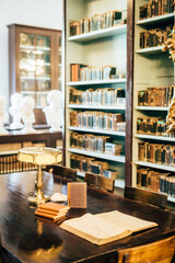 interior of an old house cabinet with books, wooden furniture and lamp