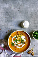 Delicious autumn pumpkin soup with cream and walnuts. Top view with copy space.