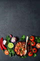 Tomato salsa (salsa roja) - traditional mexican sauce  with ingredients for making .Top view with copy space.