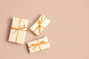 Christmas background with gift boxes wrapped in golden colored paper. Xristmas celebration, preparation for winter holidays. Festive mockup, top view, flat lay