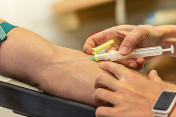A nurse preparing an intravenous injection for taking a blood sample at a patient´s arm