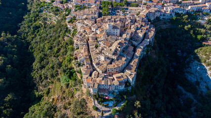 Aerial view of the horseshoe shaped narrow streets of  Tourrettes sur Loup, a stone village built on a promontory in the mountains above Nice on the French Riviera, France