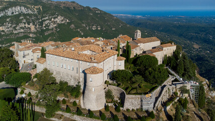 Fototapeta na wymiar Aerial view of the medieval village of Gourdon in Provence, France - Castle with a round tower built on the edge of a cliff in the mountains of the Gorges du Loup on the French Riviera