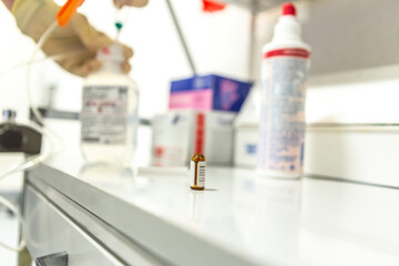 A nurse preparing an infusion, focus on the pharmaceutical phial