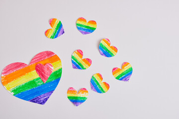 homemade rainbow hearts on a gray background, drawn and cut hearts in the colors of the lgbt pride...