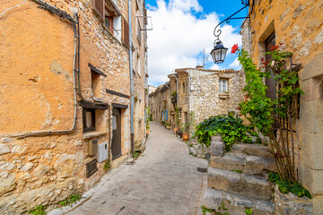 A narrow alley of apartments and homes in the historic center of the walled medieval village of Tourrettes-Sur-Loup in the Alpes-Maritimes section of southern France.