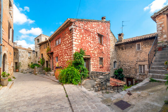 Fototapeta Homes and shops inside the narrow alleys and winding streets of the medieval stone village of Tourrettes Sur Loup in Southern France.