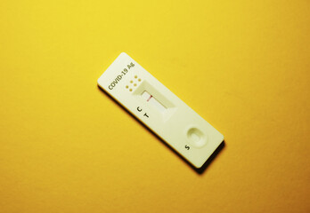 A picture of collection device Covid-19 antigen self test kit showing negative result on yellow background
