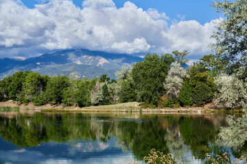 Scenic View of Colorado Springs Lake with reflection of Trees, Mountain and Clouds in Lake 