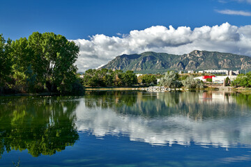 Scenic View of Colorado Springs Lake with mirror reflection of Mountains and White Clouds in Lake 