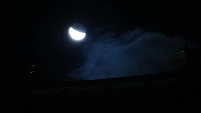Japanese old castle and half moon. Waning moon. Moving cloud