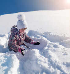 Fototapeta na wymiar Winter sunny day, child playing with snow, sparkling snow