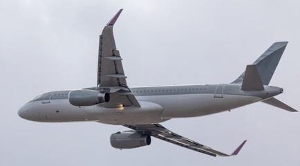 A commercial passenger plane flies in the sky. Bottom view.