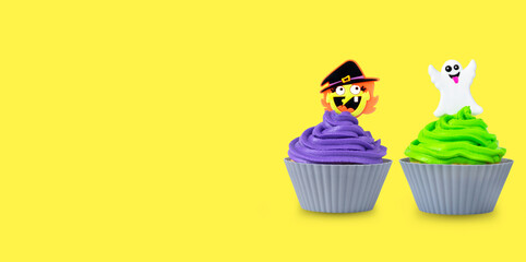 bright halloween cupcakes with green and purple cream and ghost and witch decor on yellow background