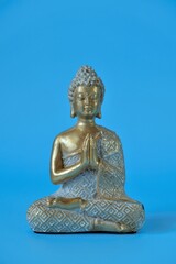 Buddha statue on a blue background.Meditation and relaxation .Buddhism religion background. 