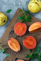 Guava fruit or Psidium Guava on wooden chopping board , on grey grainy background. 