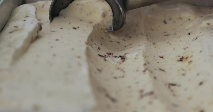 Scooping Cookies and Cream ice cream out from container with a spoon, Food concept, Front view Blank for design.