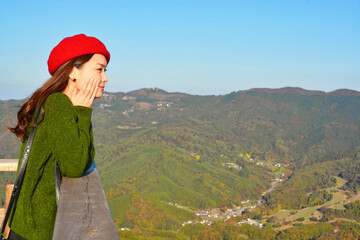 Fototapeta na wymiar 秋の紅葉の風景を眺める女性
