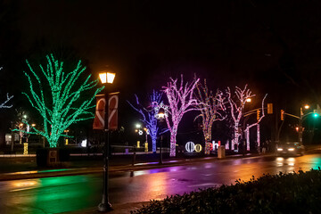 Wet streets reflecting the bright colors of the festive lights