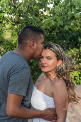 Hispanic Couple in the park. boyfriend kissing girlfriend.