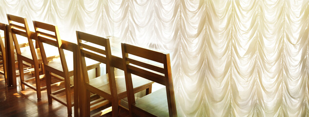 row of wood chair with sunlight from white curtain window interior banner background